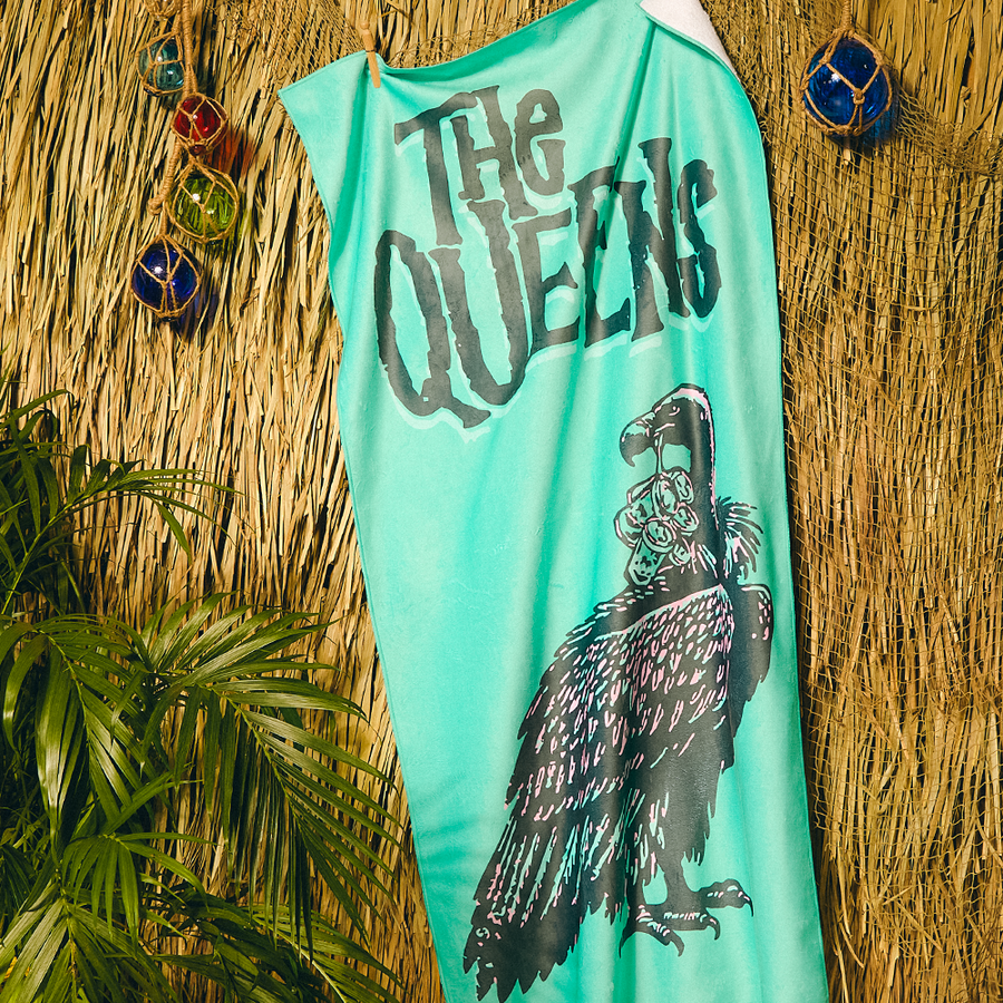 Turquoise sleeveless shirt with black text and bird graphic on a straw background