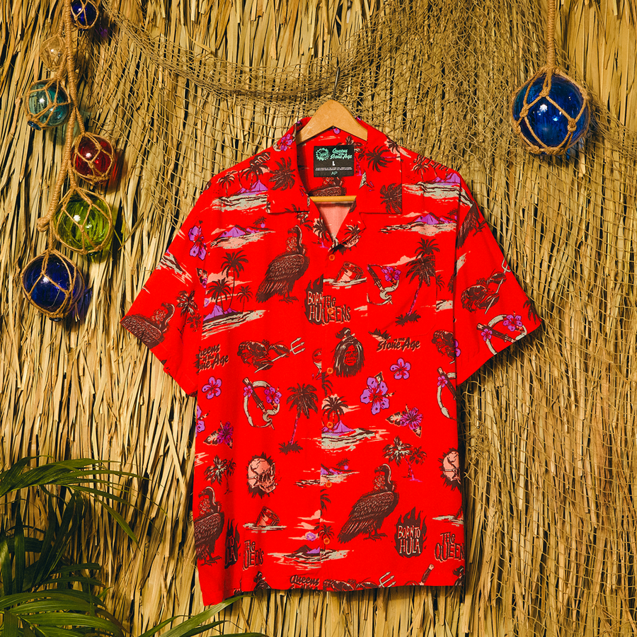 Red patterned shirt on a hanger against a straw wall background